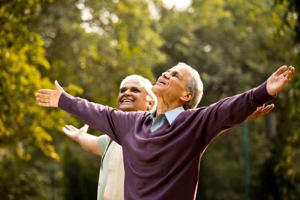 Two carefree elderly men with arms 