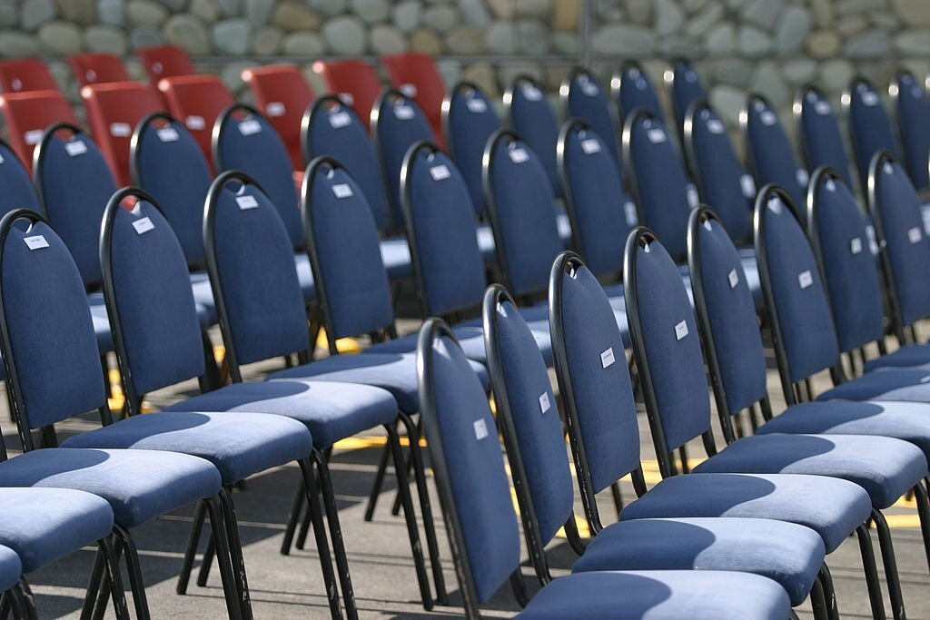 Blue and red visitors chairs at a public event, waiting for the crowd to arrive.
