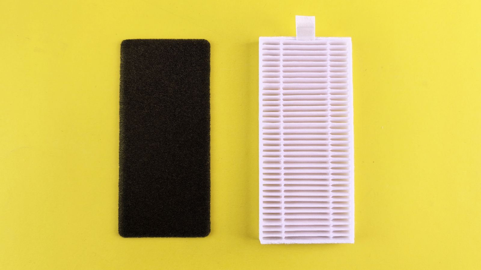 Pleated white air filter next to a black foam pre-filter