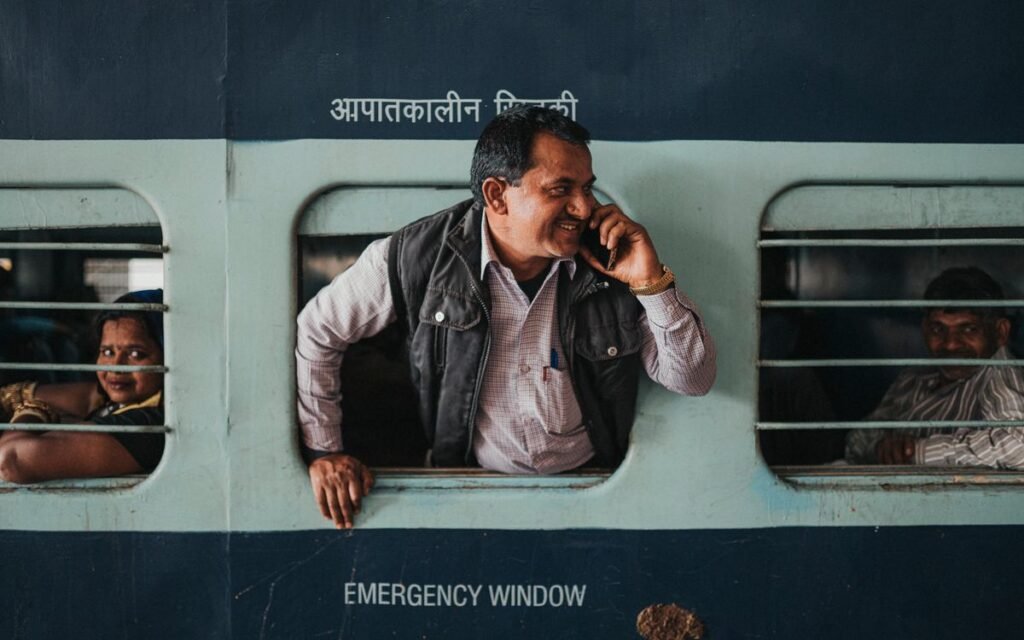 man talking on his phone from a train window in Jaipur, a typical calls-first mobile user in India