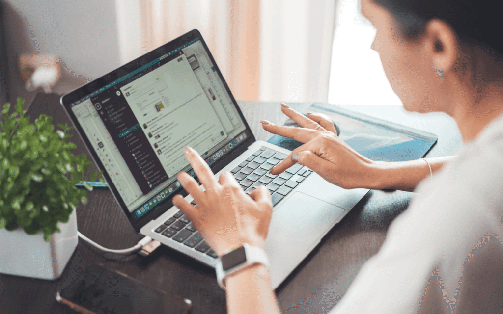 hands typing on a laptop with a chat app open
