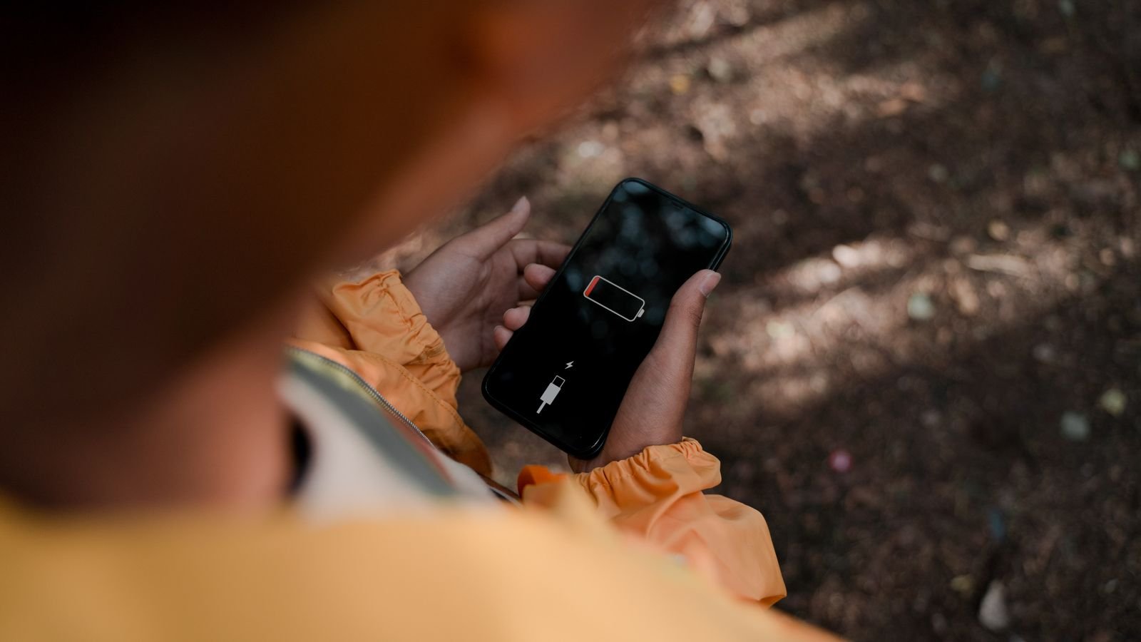 battery health: hand holding a phone showing a low battery warning