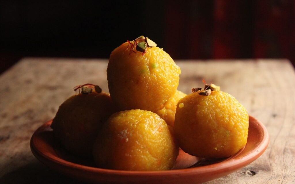 Plate of laddoos topped with pistachio and saffron