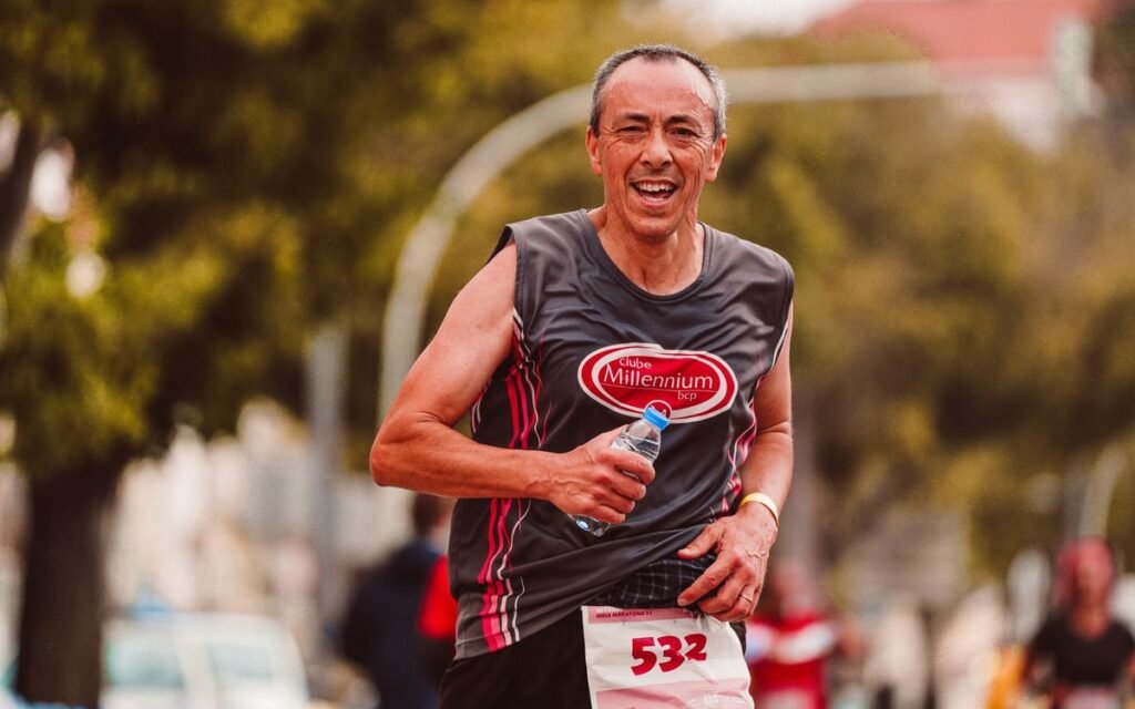 smiling marathon runner holding a water bottle during a race