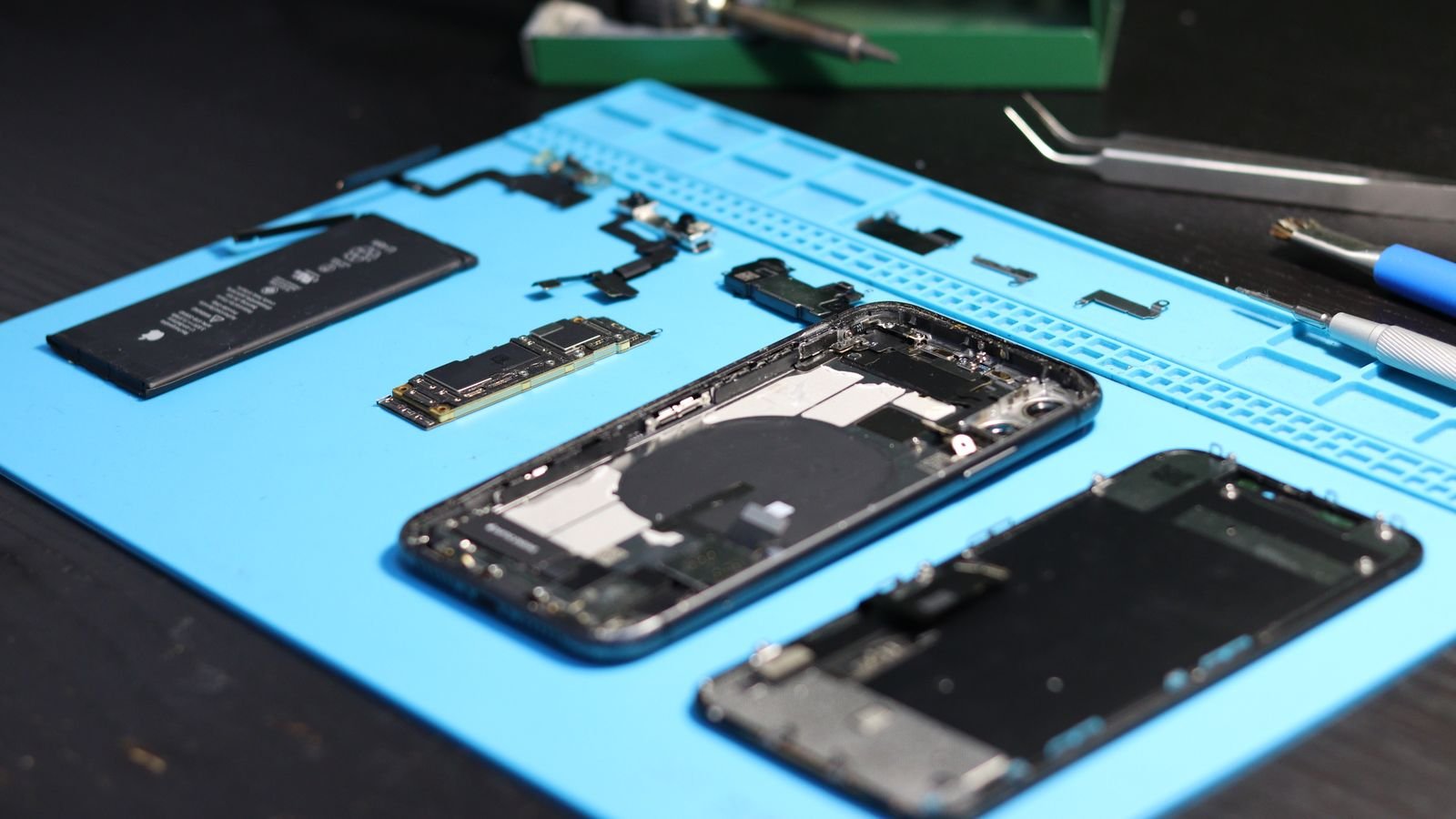 extended warranty: an opened smartphone and parts on a repair mat