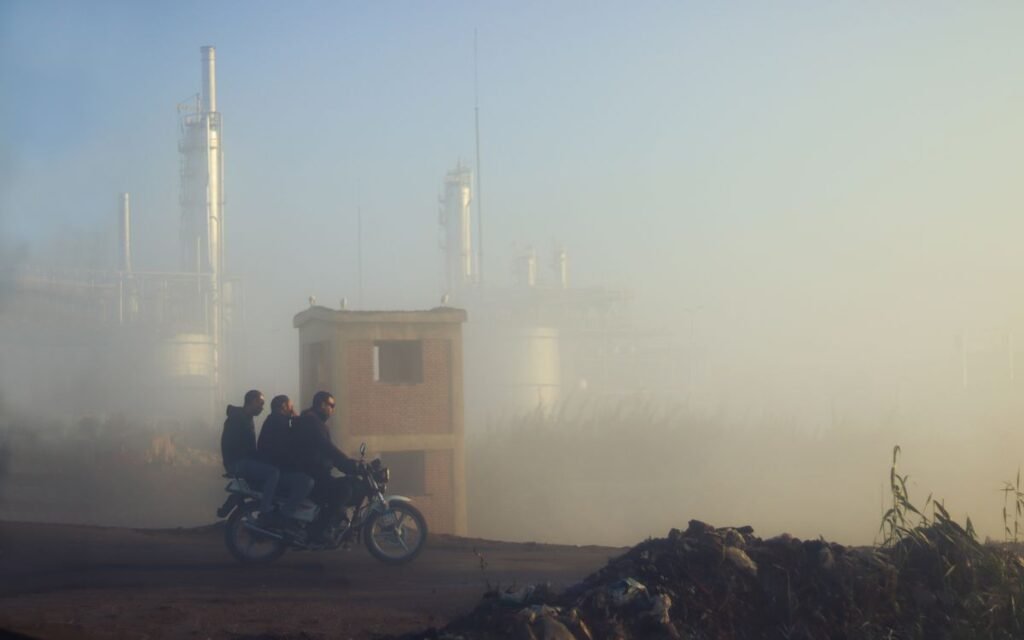 three men on a motorcycle on a smoggy road