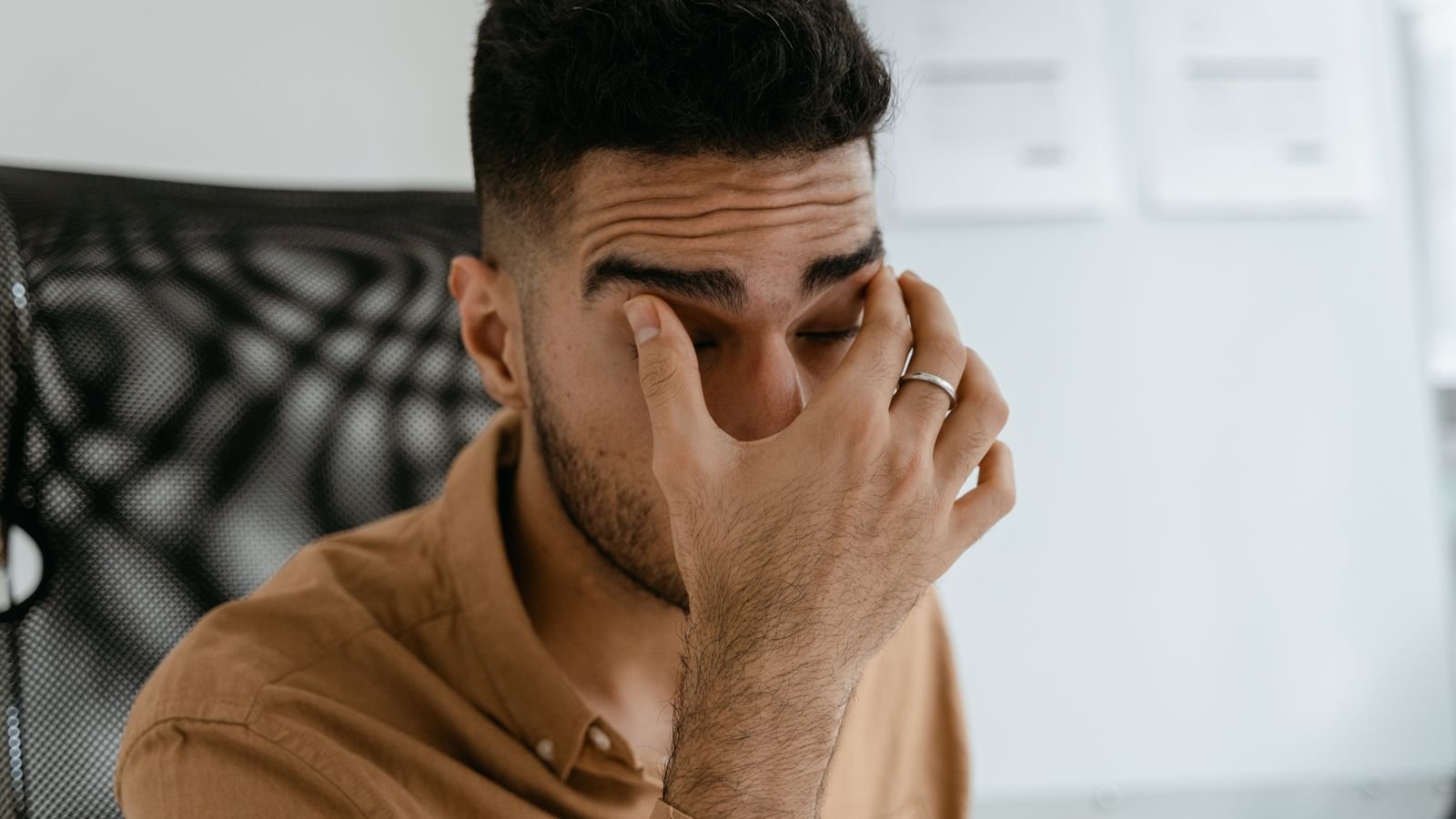 eye irritation from pollution: man rubbing his irritated eye