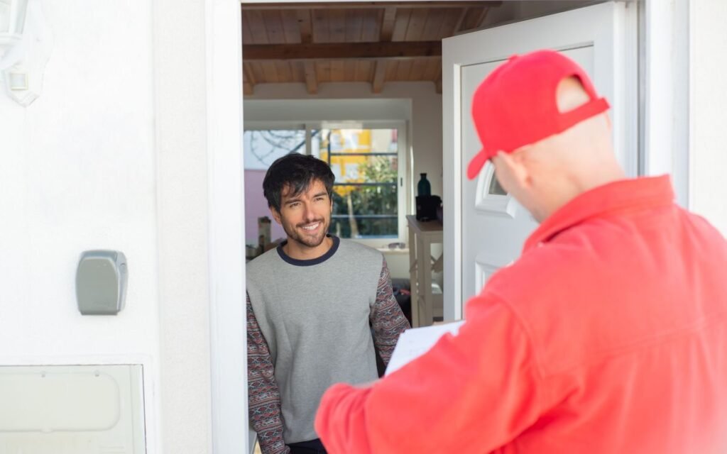 a courier handing over a delivery at a front door