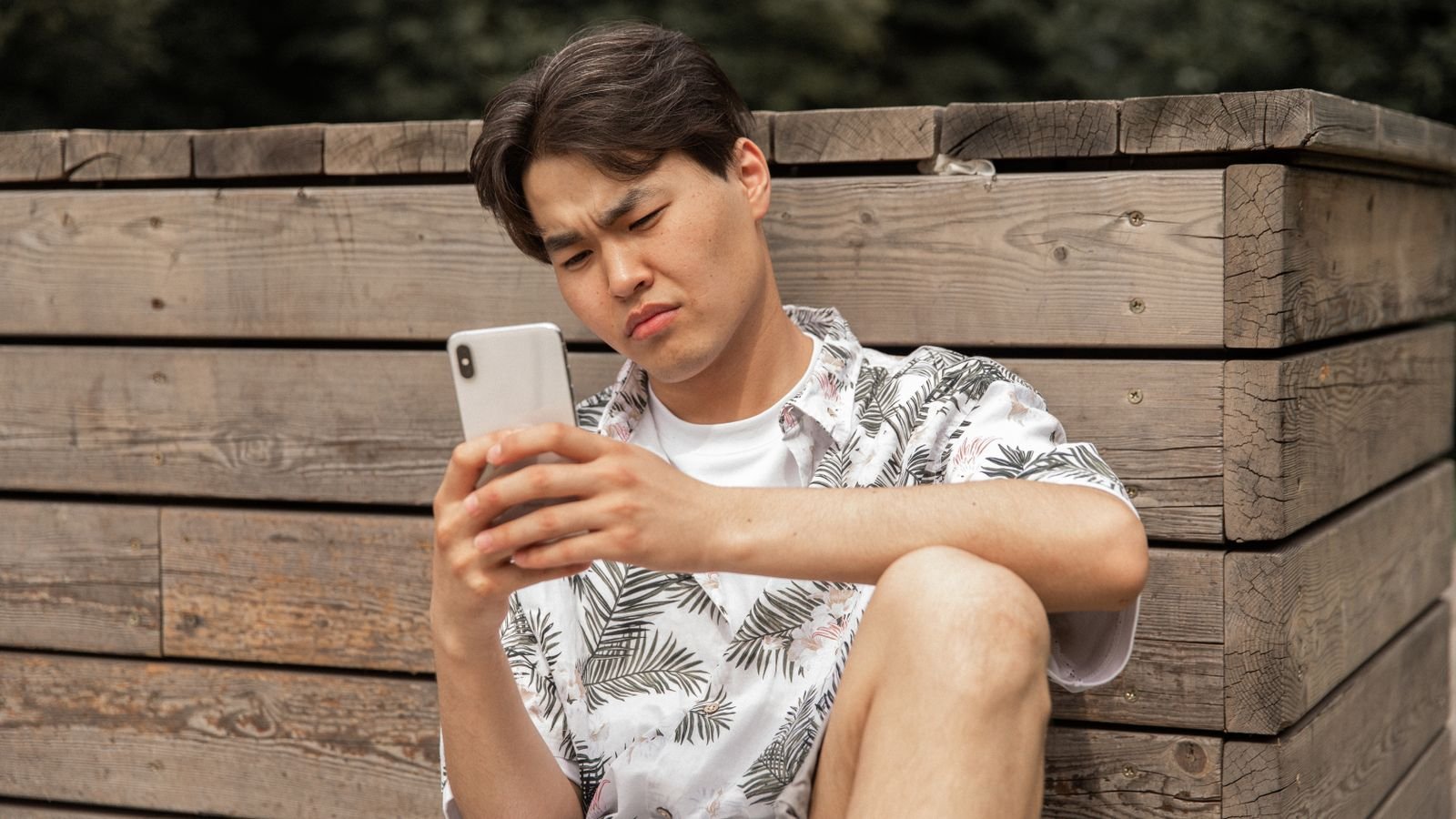 fake delivery sms: a man squinting suspiciously at his phone