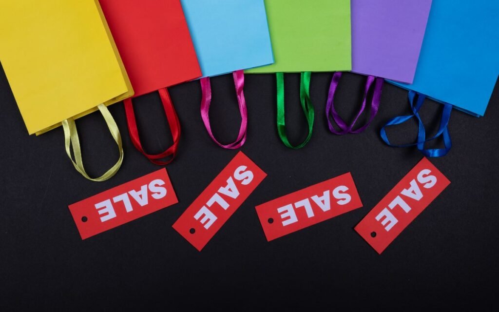 Colourful shopping bags with red sale tags