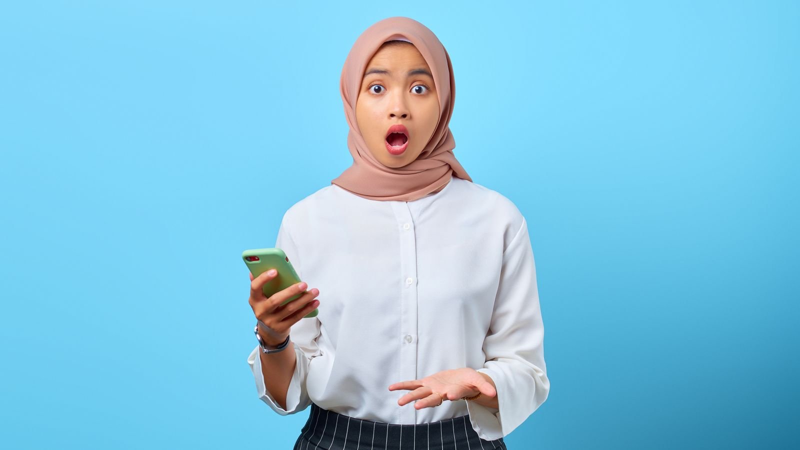 Young woman looking surprised at a price on her phone