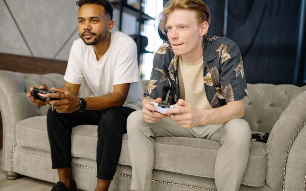 two friends playing a video game on a sofa