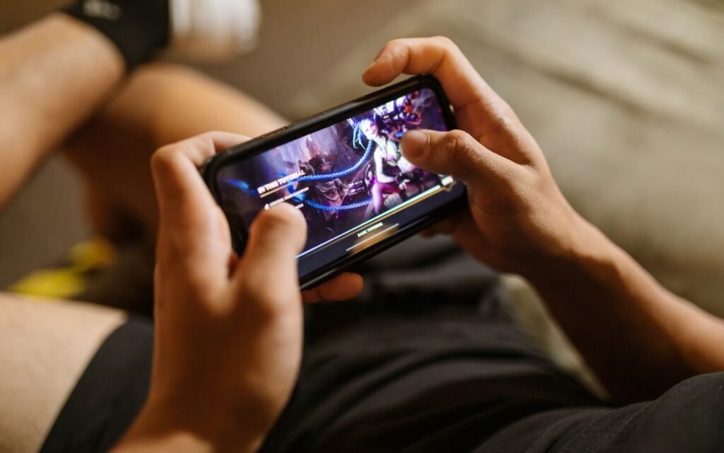 Close-up of hands gripping a phone sideways during a mobile game
