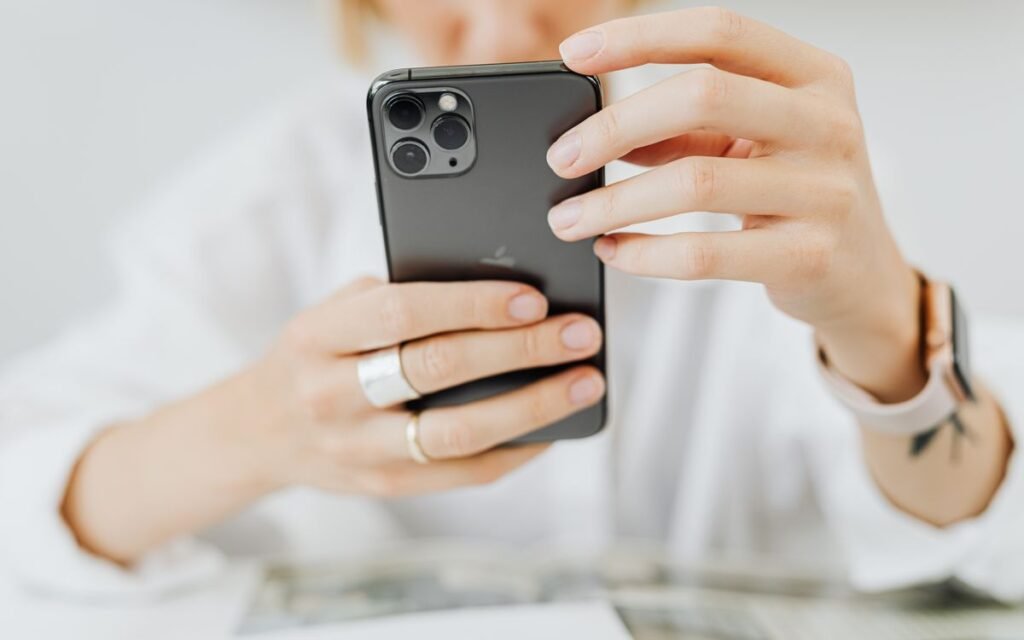 Person holding an iPhone with a triple camera in both hands