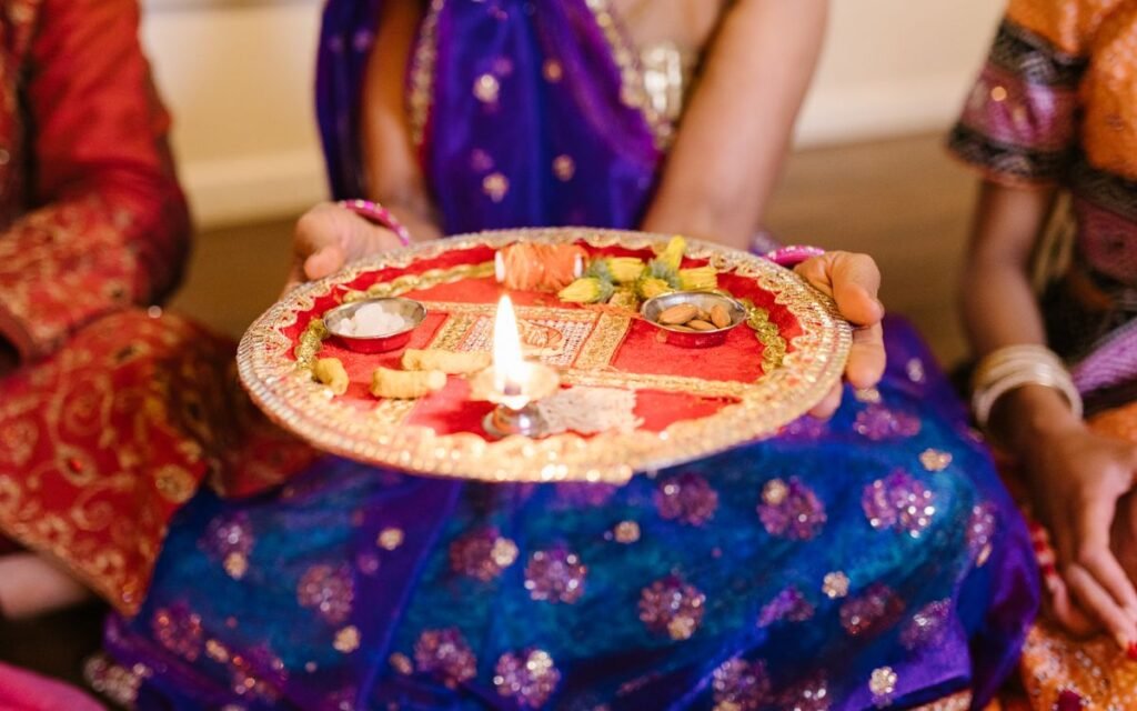Decorated puja thali with a lit diya
