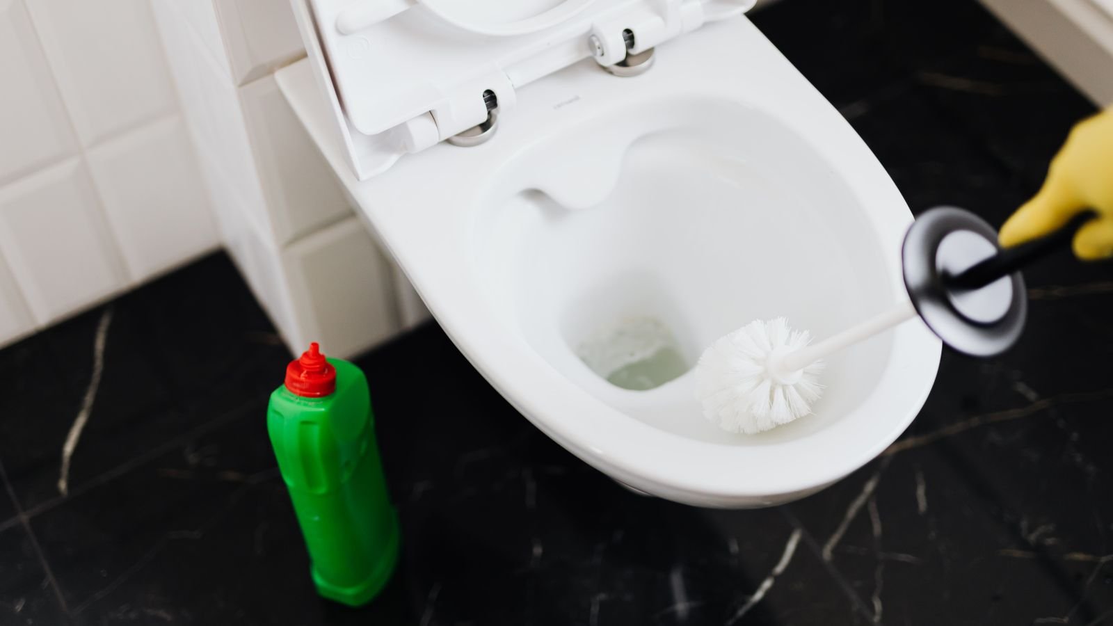 mixing cleaning products: a toilet being cleaned, a cleaner bottle beside it