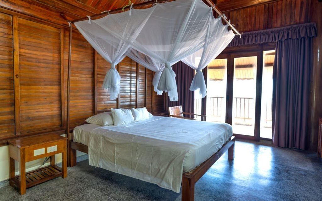 Mosquito net draped over a bed in a bright bedroom