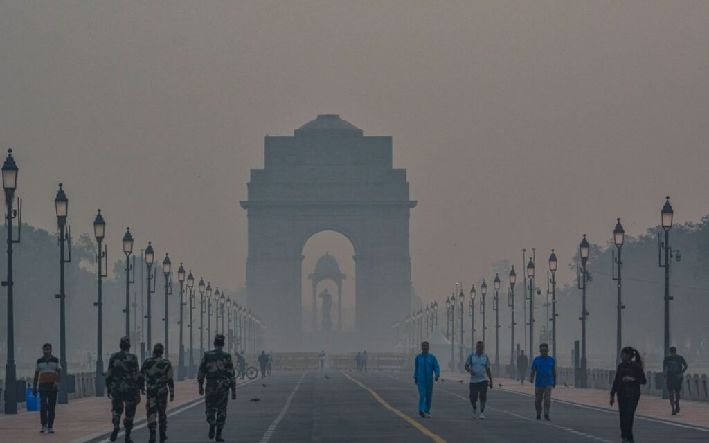 Morning walkers on Kartavya Path with India Gate hidden in smog, New Delhi