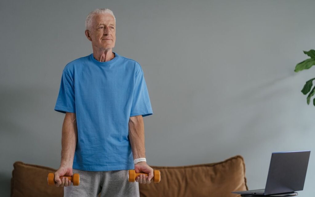 Older man lifting light dumbbells at home