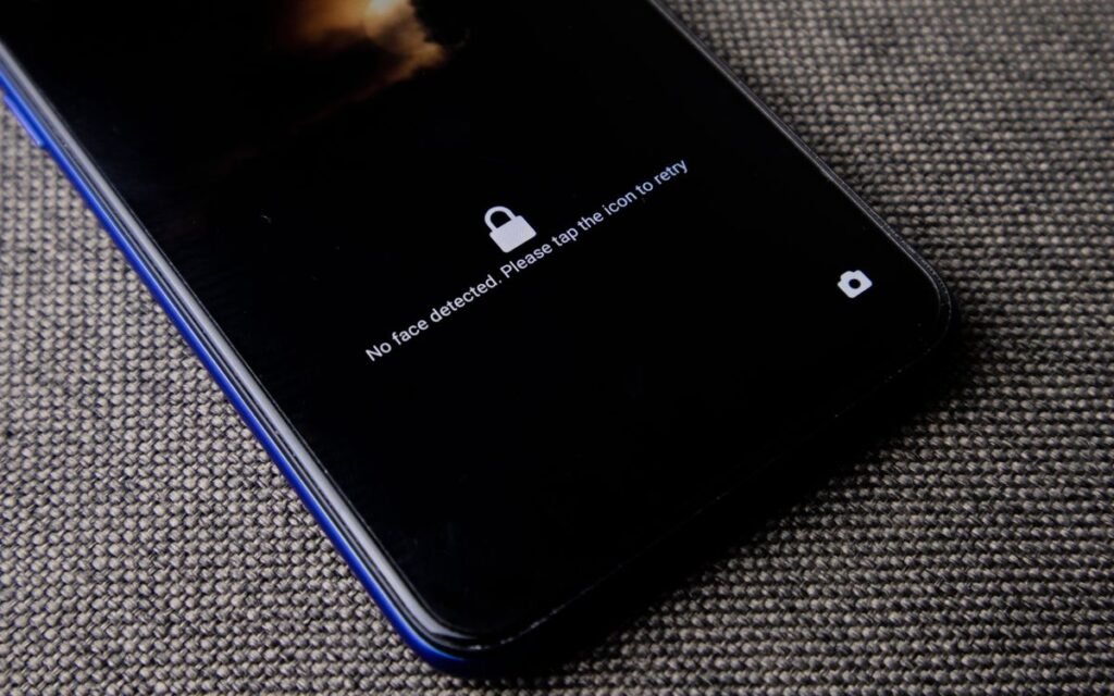 A smartphone lock screen showing a face unlock prompt on a fabric surface