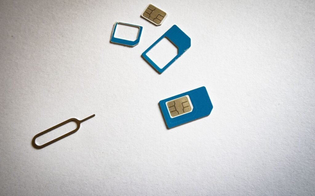 SIM cards in different sizes next to a SIM ejector pin