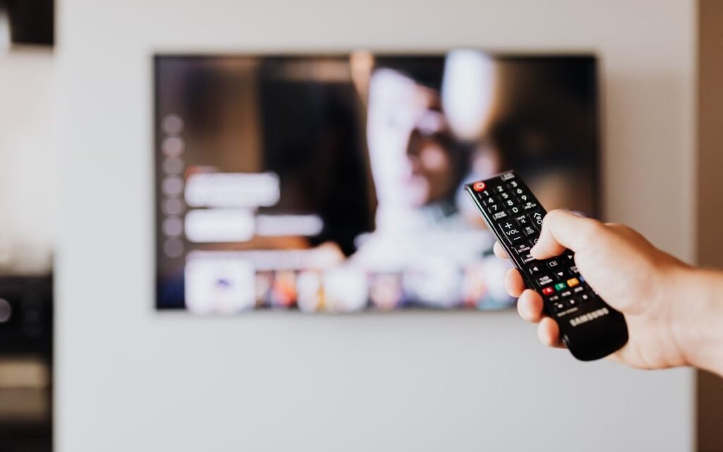 smart tv slow: hand pointing a remote at a smart TV menu