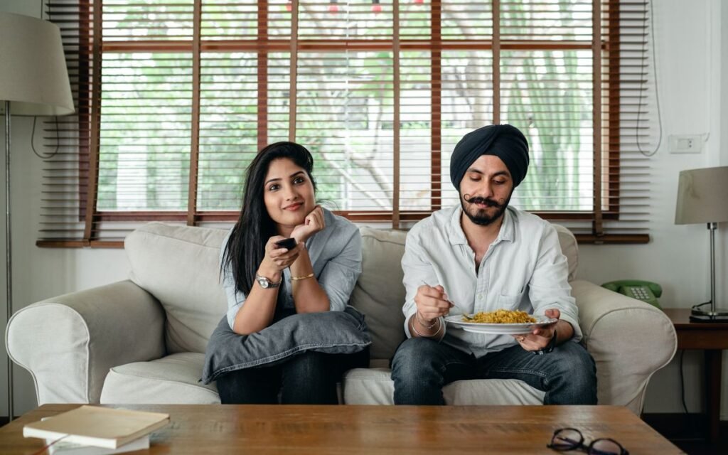 smart tv slow fix: couple on a sofa with a TV remote