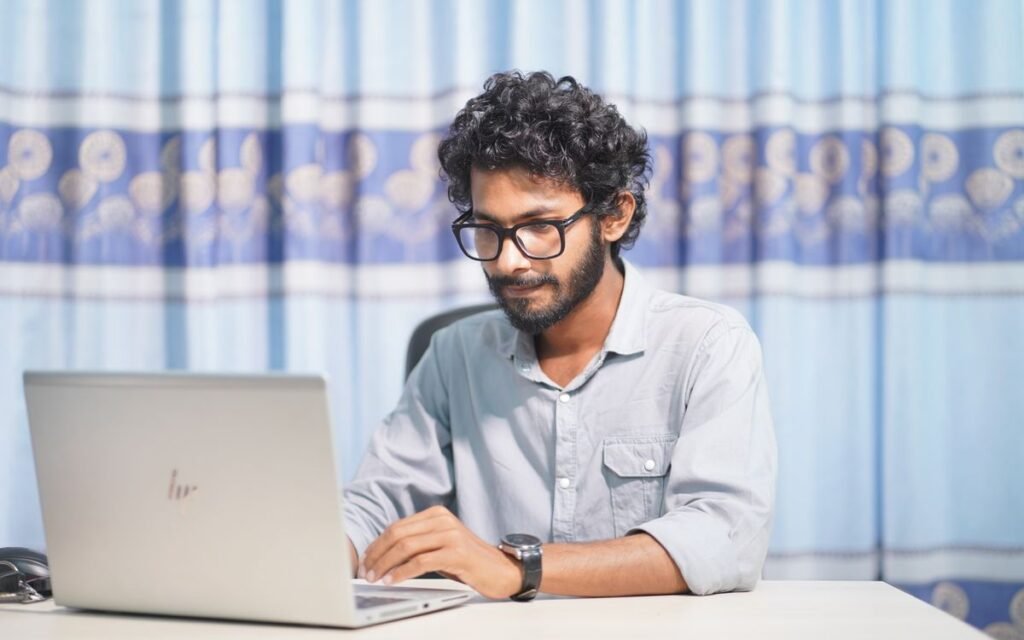 young man working on a laptop at a desk