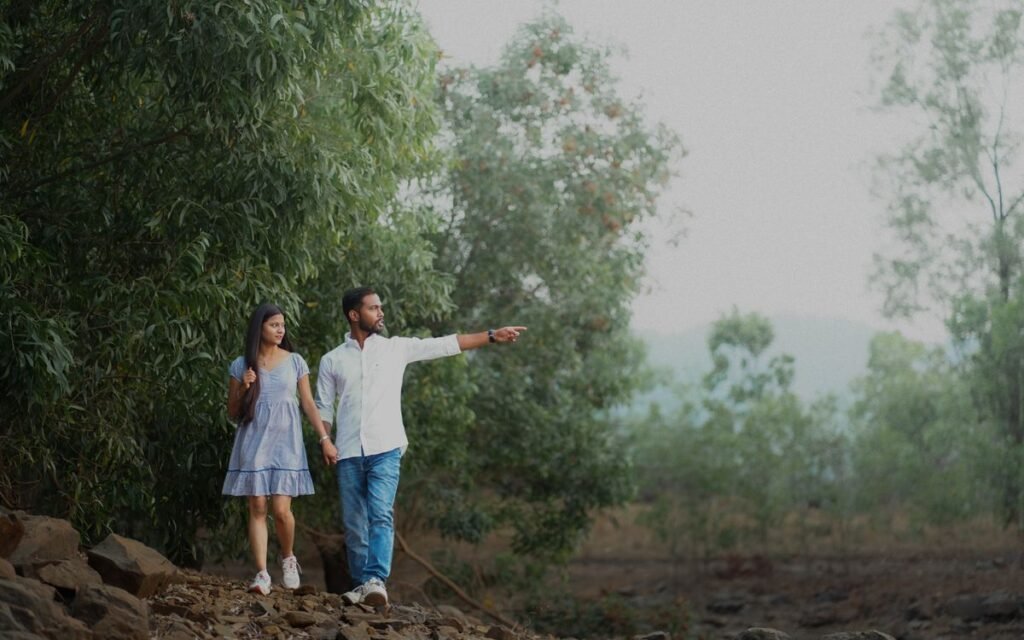 Young Indian couple walking hand in hand on a misty path